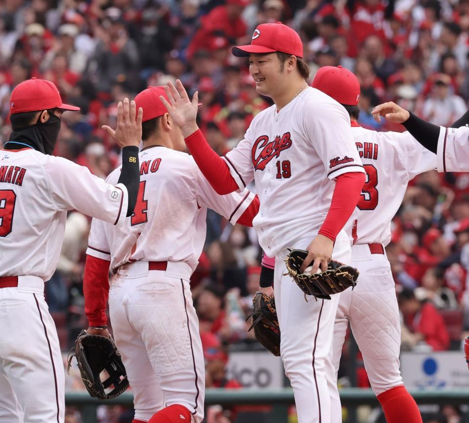 　今季初勝利を完封で飾り、チームメートとタッチを交わす床田（撮影・市尻達拡）