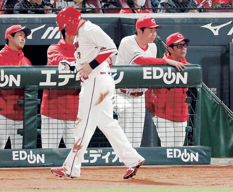 　６回、三本間に挟まれ、タッチアウトになりベンチに戻る会沢。後方は新井監督（撮影・市尻達拡）