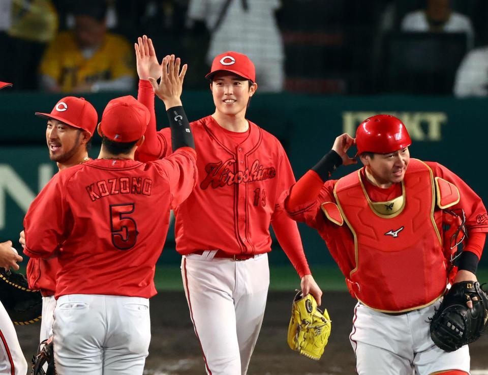 　完投勝利を飾り笑顔でナインとタッチする森下（中央）＝撮影・山口登