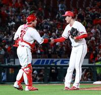 　試合を締め、会沢と握手を交わす岡本（撮影・市尻達拡）