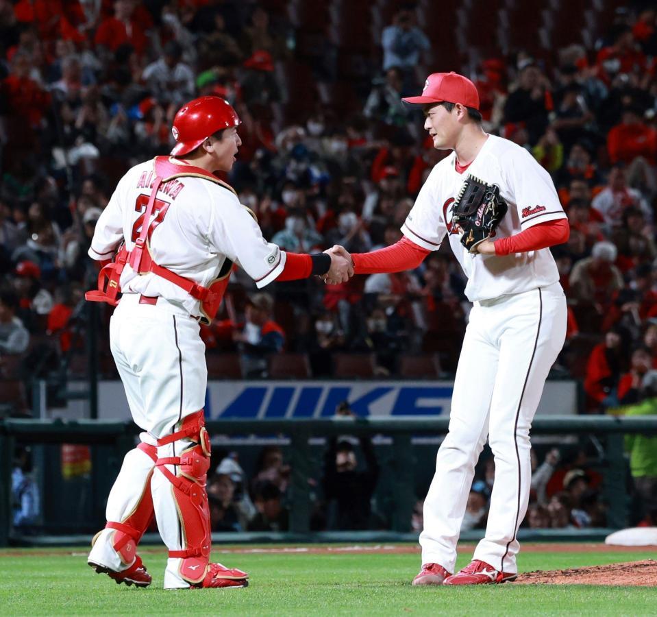 　試合を締め、会沢と握手を交わす岡本（撮影・市尻達拡）