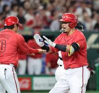 　４回、同点２ランを放ち、コーチとタッチを交わす末包