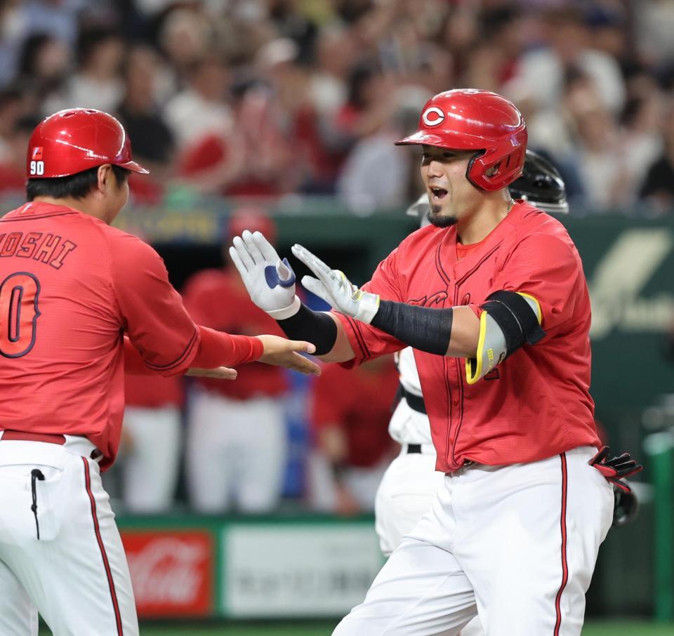 　４回、同点２ランを放ち、コーチとタッチを交わす末包