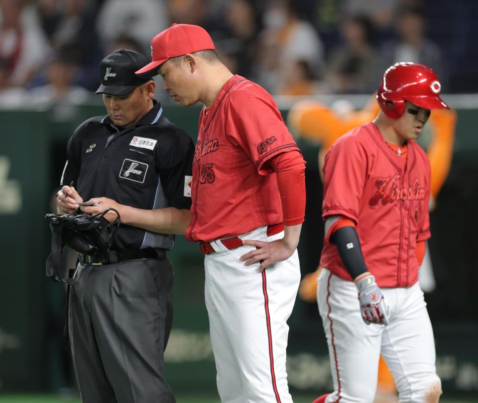 　１１回、三振に倒れた小園（右）の横で選手交代を告げる新井監督（撮影・西岡正）