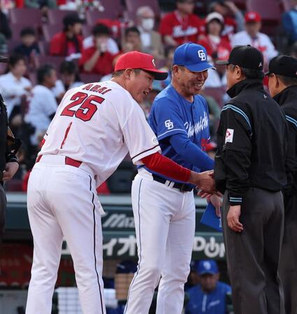 　メンバー表を交換し、審判団と握手をする新井監督（左）と井上監督（撮影・市尻達拡）