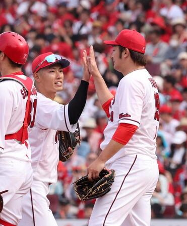 　勝利のタッチで、床田と手を合わせる中村奨（撮影・市尻達拡）