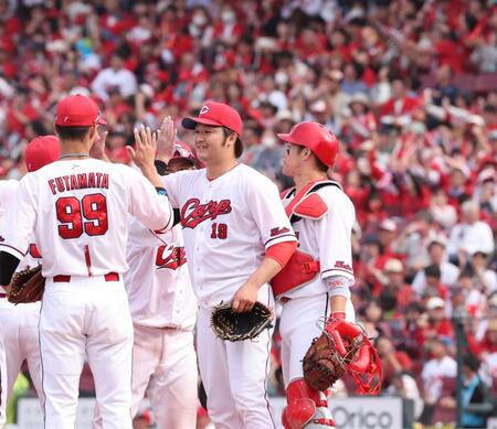 　完封勝利でチームの連敗を止め、チームメートとタッチを交わす床田（撮影・市尻達拡）