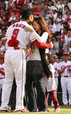 　花束を手渡し涙で抱擁するかな子夫人＝２００９年１０月１０日