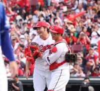 　完封勝利でチームの連敗を止め、坂倉と喜びを分かち合う床田（撮影・市尻達拡）