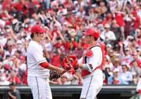 　完封勝利でチームの連敗を止め、坂倉と握手を交わす床田（撮影・市尻達拡）