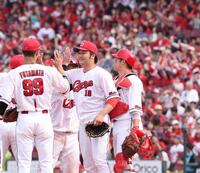 　完封勝利でチームの連敗を止め、チームメートとタッチを交わす床田（撮影・市尻達拡）