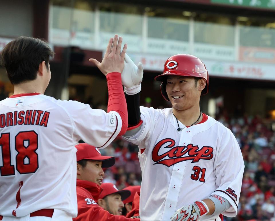 　２回、右越えソロを放ち、タッチを交わす坂倉（撮影・市尻達拡）