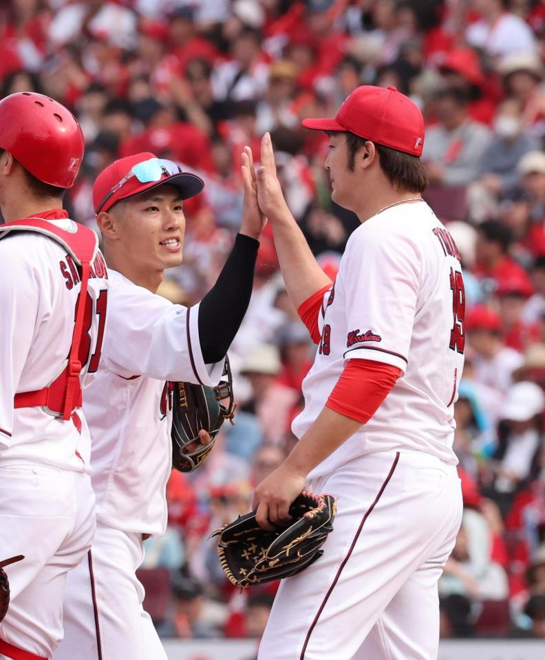 　勝利のタッチで、床田と手を合わせる中村奨（撮影・市尻達拡）