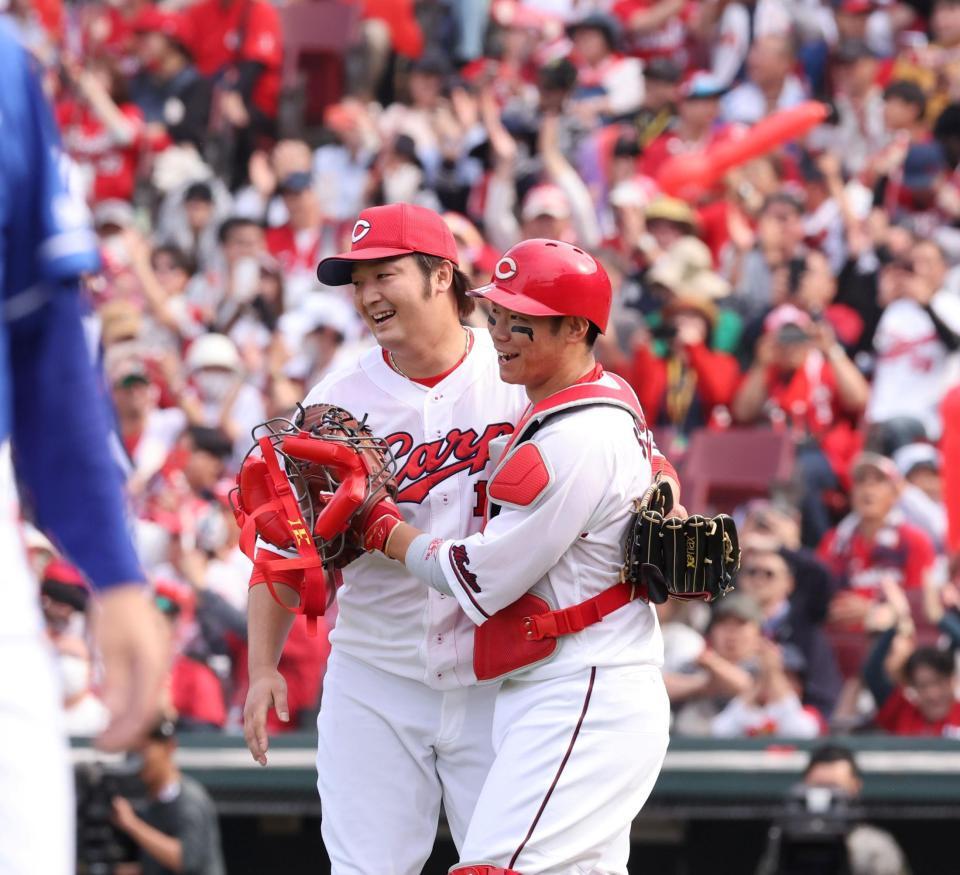 　完封勝利でチームの連敗を止め、坂倉と喜びを分かち合う床田（撮影・市尻達拡）