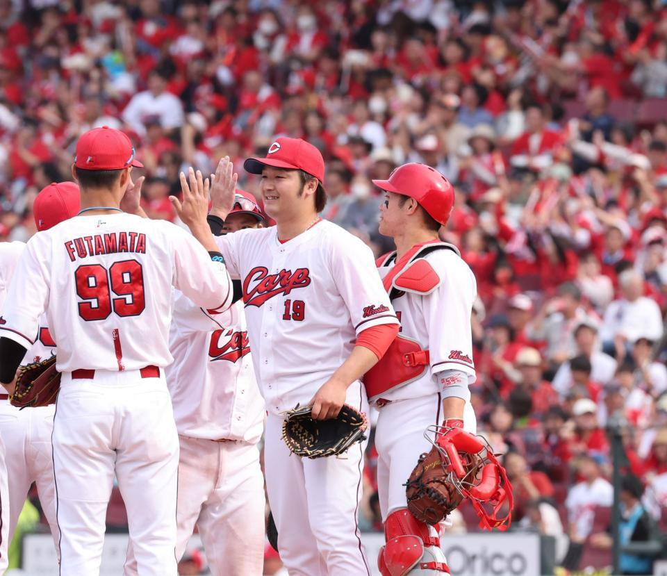 　完封勝利でチームの連敗を止め、チームメートとタッチを交わす床田（撮影・市尻達拡）