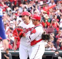 　完封勝利でチームの連敗を止め、坂倉と喜びを分かち合う床田（撮影・市尻達拡）