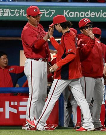 　移籍後初勝利を挙げた鈴木（中央）とタッチを交わす新井監督（左）