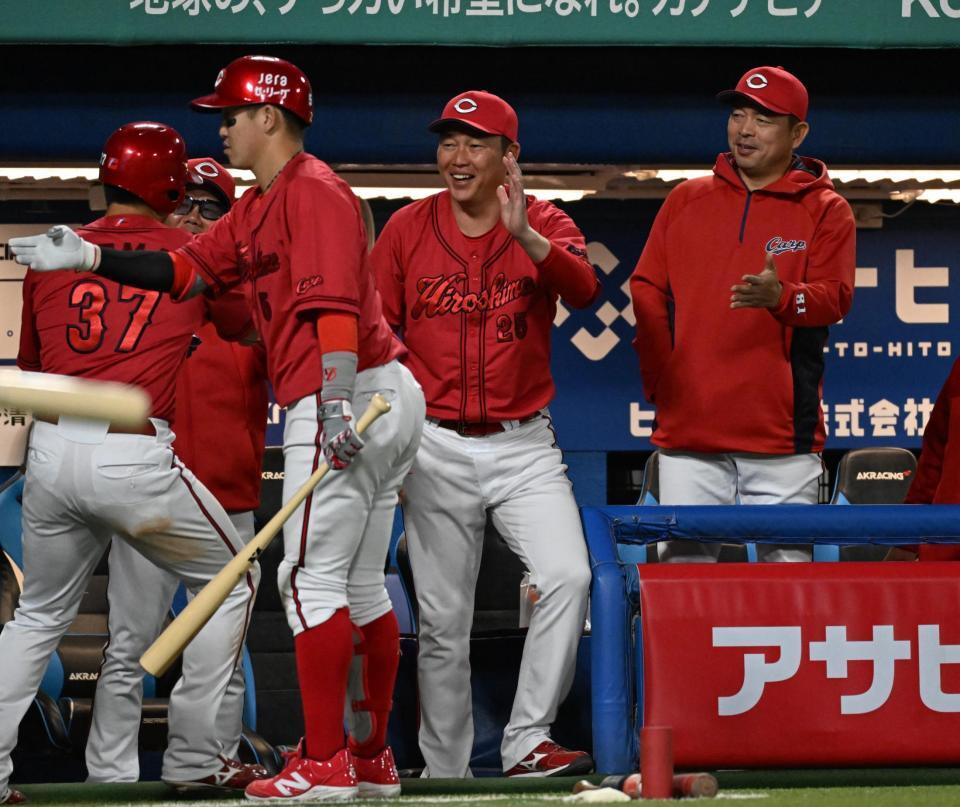 　７回、末包の２点打で生還した野間（３７）らを迎える新井監督（中央）