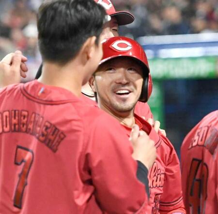 　９回、菊池（右）は１号ソロを放ち、堂林に迎えられる