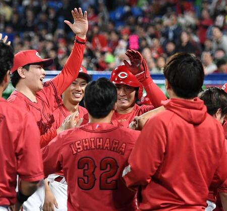 　９回、堂林（中央）は左越えに勝ち越しの１号ソロを放ち、大瀬良（左）らに祝福される（撮影・佐藤厚）