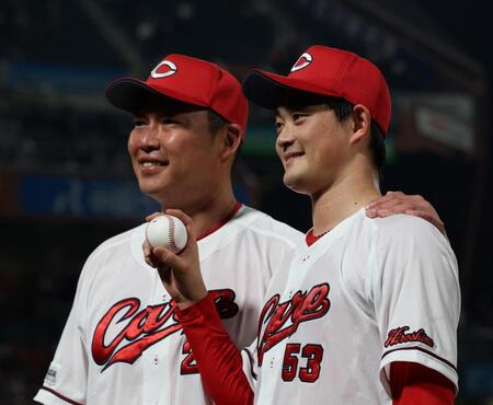 プロ初勝利を手にし、記念球を持ち新井監督（左）と記念撮影に応じる岡本（撮影・市尻達拡）