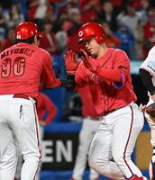 ９回、勝ち越しソロを放ち三好コーチ（左）に迎えられる堂林