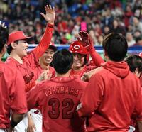 　９回、堂林（中央）は左越えに勝ち越しの１号ソロを放ち、大瀬良（左）らに祝福される（撮影・佐藤厚）