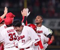 １２回、サヨナラ打を放ち、ナインとタッチを交わすモンテロ（右）＝撮影・市尻達拡