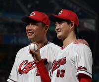 プロ初勝利を手にし、記念球を持ち新井監督（左）と記念撮影に応じる岡本（撮影・市尻達拡）