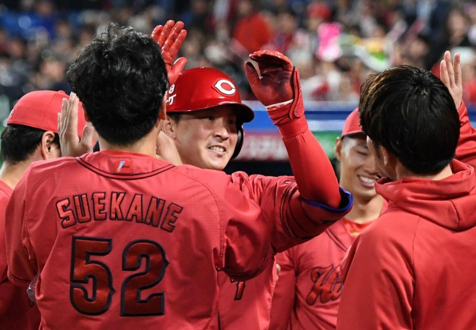 　９回、堂林（中央）は左越えに勝ち越しの１号ソロを放ち、ナインから祝福される（撮影・佐藤厚）