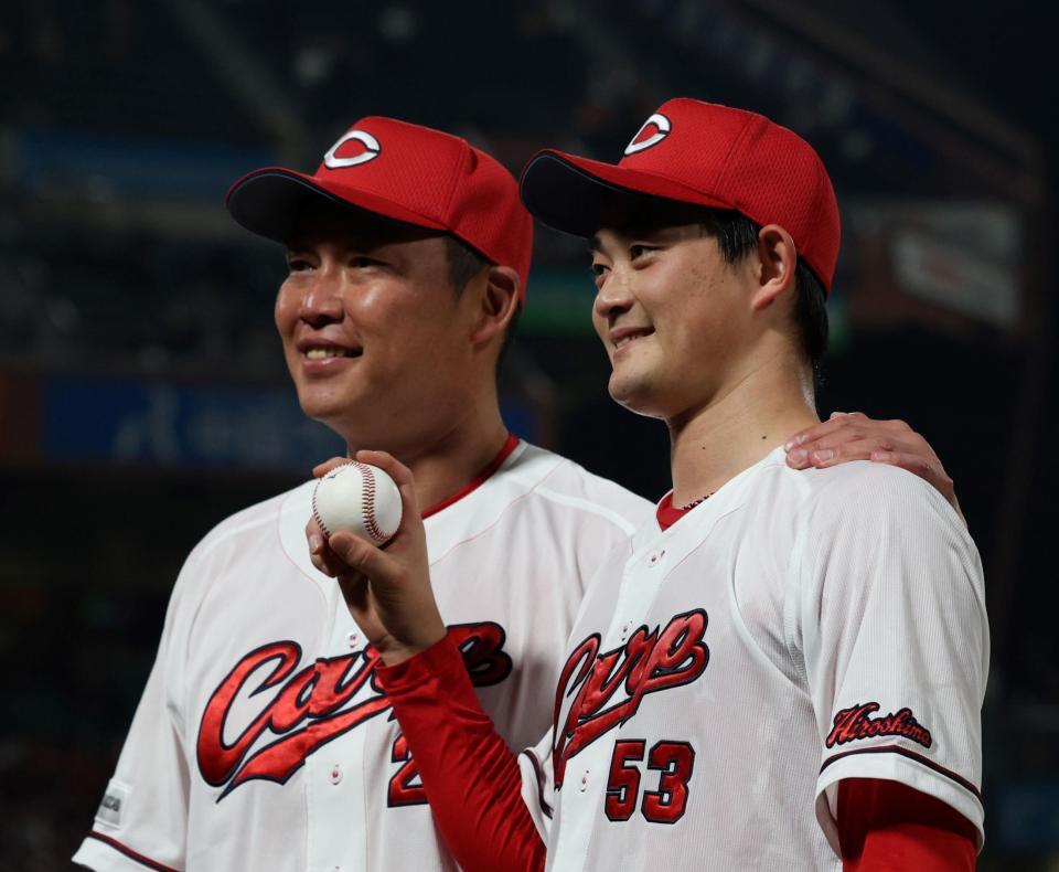 プロ初勝利を手にし、記念球を持ち新井監督（左）と記念撮影に応じる岡本（撮影・市尻達拡）