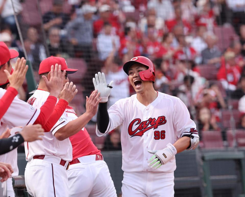 ２回、左中間席へソロを放ち、タッチを交わす中村奨（撮影・市尻達拡）