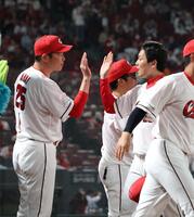 　新井監督と勝利のタッチを交わす栗林（撮影・市尻達拡）