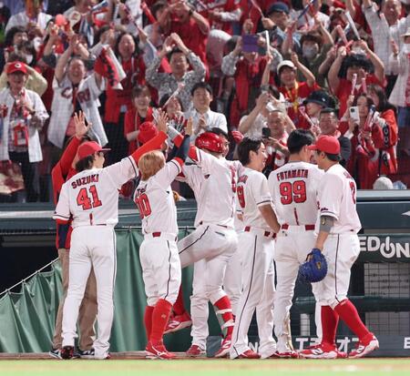 　６回、右越え満塁本塁打を放ち、チームメートに出迎えられる小園（撮影・市尻達拡）