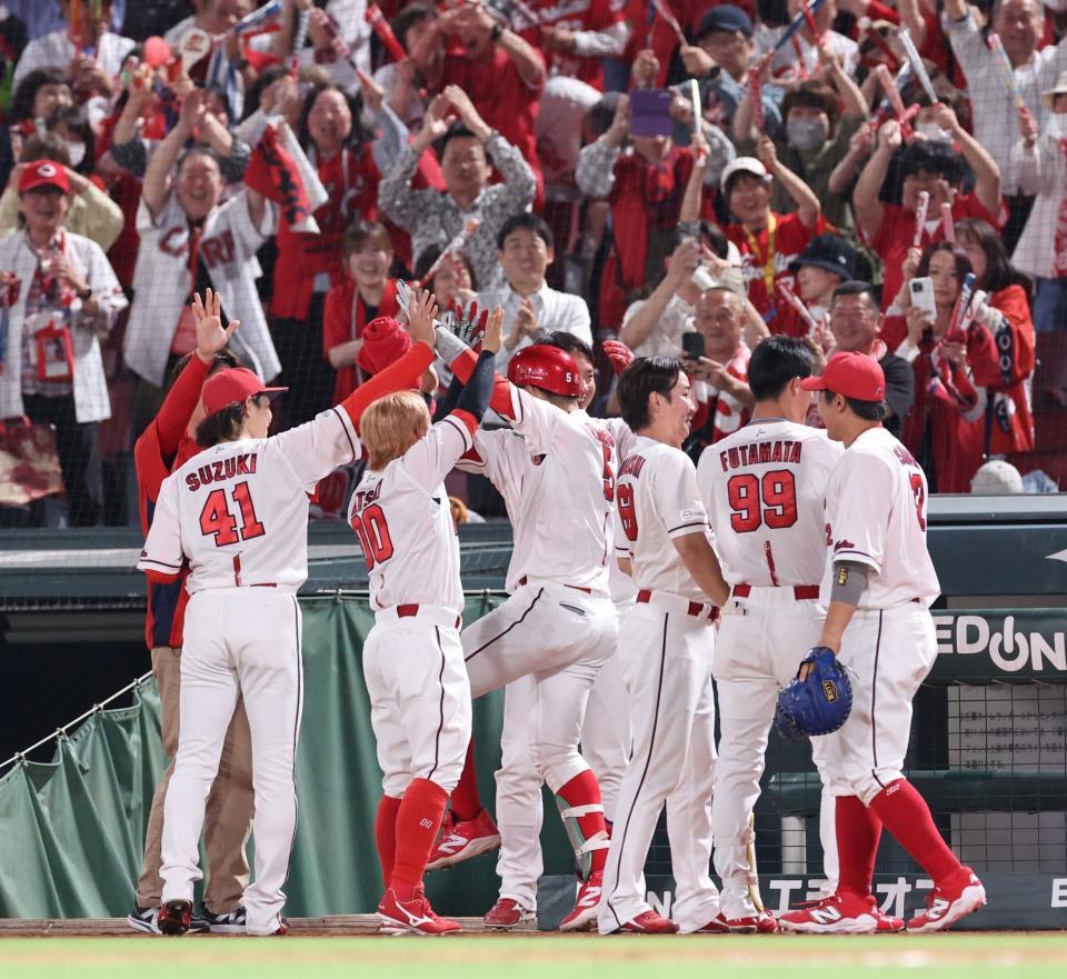 　６回、右越え満塁本塁打を放ち、チームメートに出迎えられる小園（撮影・市尻達拡）