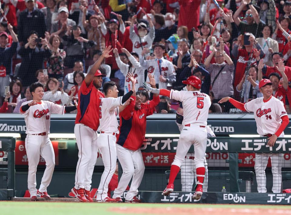 　６回、右越え満塁本塁打を放ち、チームメートに出迎えられる小園（撮影・市尻達拡）