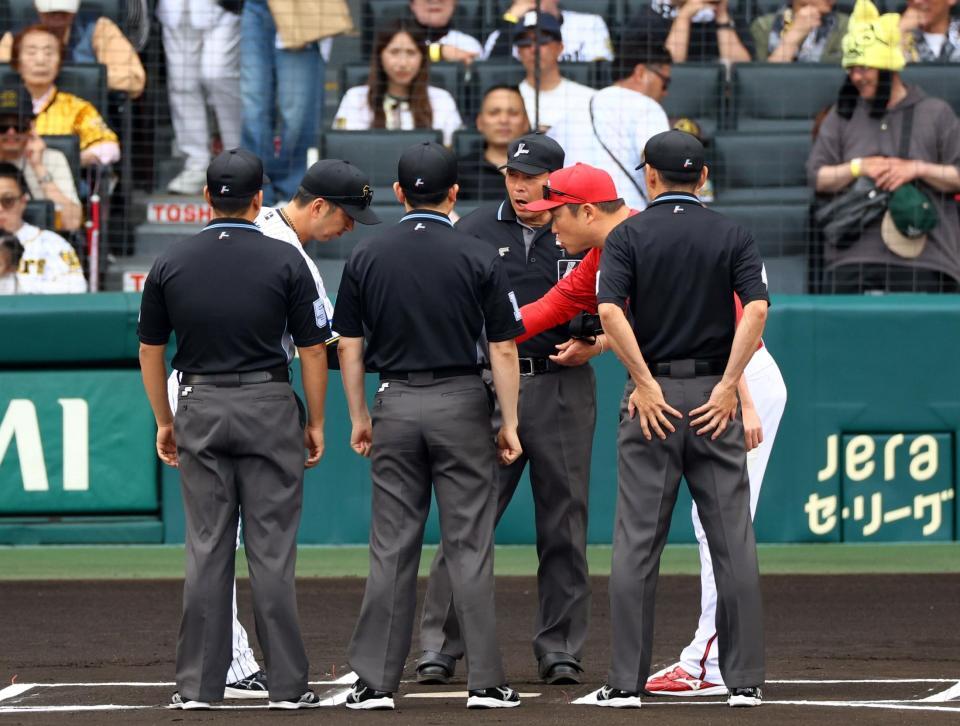 　メンバー表の交換を終え、握手をかわす藤川監督と新井監督（撮影・山口登）