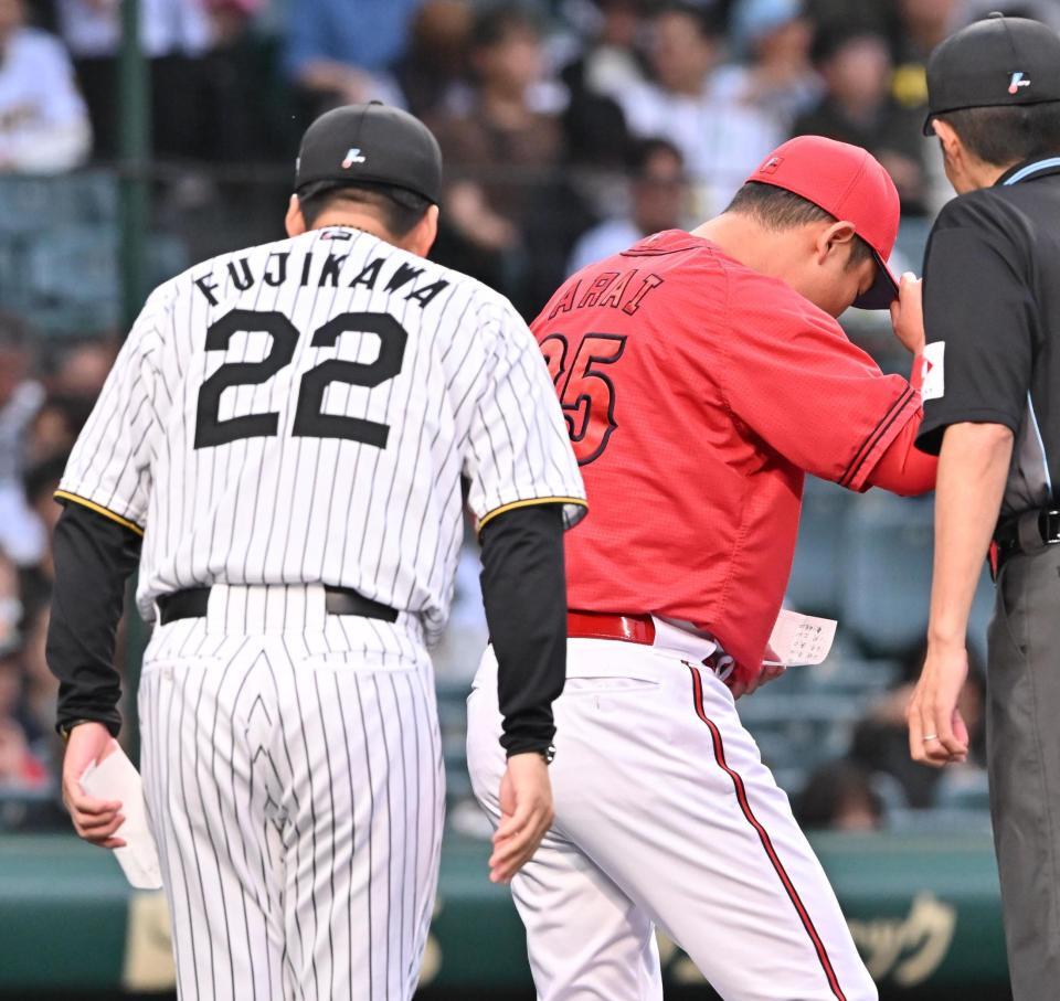 　メンバー表の交換を終えベンチに戻る新井監督（右）＝１６日