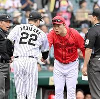 　メンバー表を交換し、藤川監督（左）と握手を交わす新井監督（撮影・西田忠信）