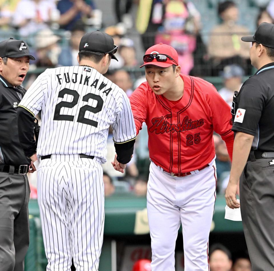 　メンバー表を交換し、藤川監督（左）と握手を交わす新井監督（撮影・西田忠信）