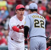 　メンバー表を確認し、握手をする藤川監督と新井監督（撮影・田中太一）