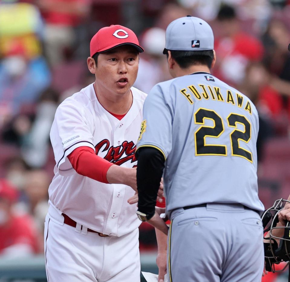 　メンバー表を確認し、握手をする藤川監督と新井監督（撮影・田中太一）