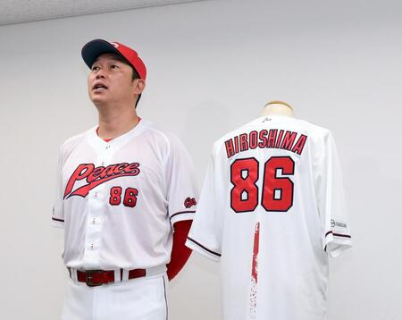 　ピースナイターで着用する特別ユニホームをを着用し、思いを語る新井監督（撮影・市尻達拡）