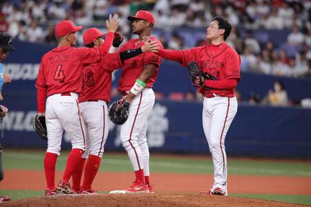 　最後を締めた栗林（右）はナインとタッチをかわす（撮影・坂部計介）