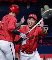 　１回、末包の適時打で生還した小園（左）を迎える新井監督