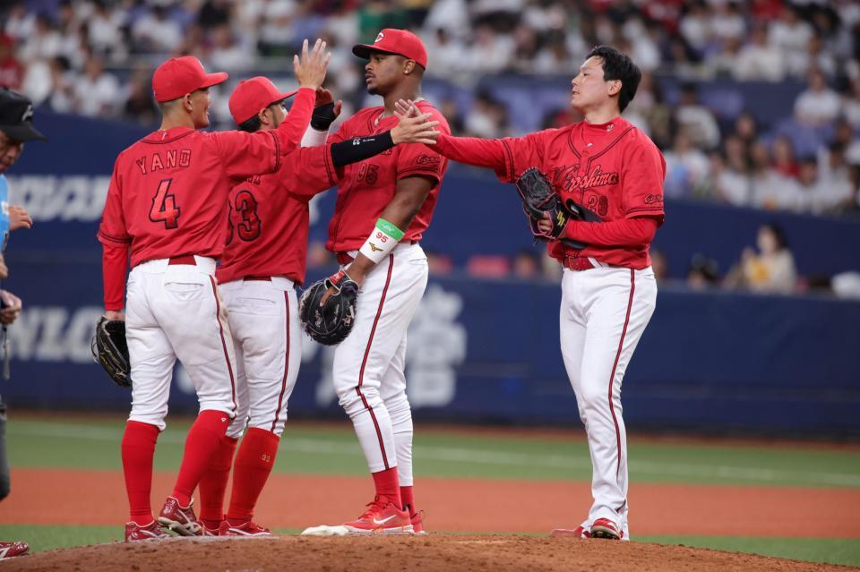 　最後を締めた栗林（右）はナインとタッチをかわす（撮影・坂部計介）