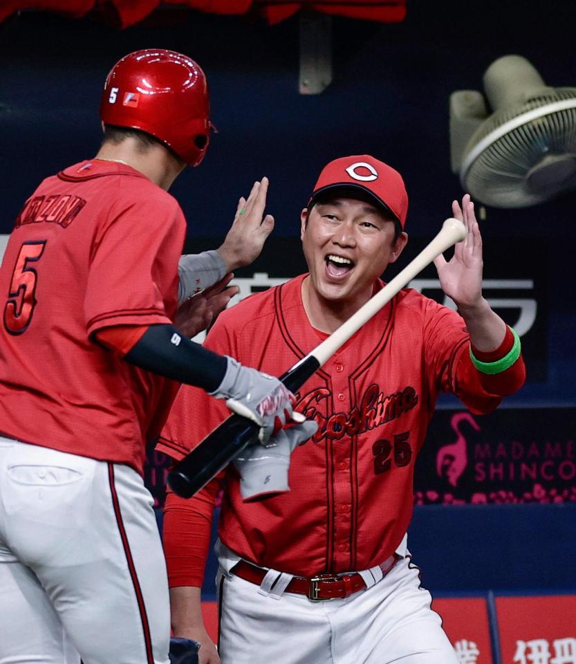 　１回、末包の適時打で生還した小園（左）を迎える新井監督