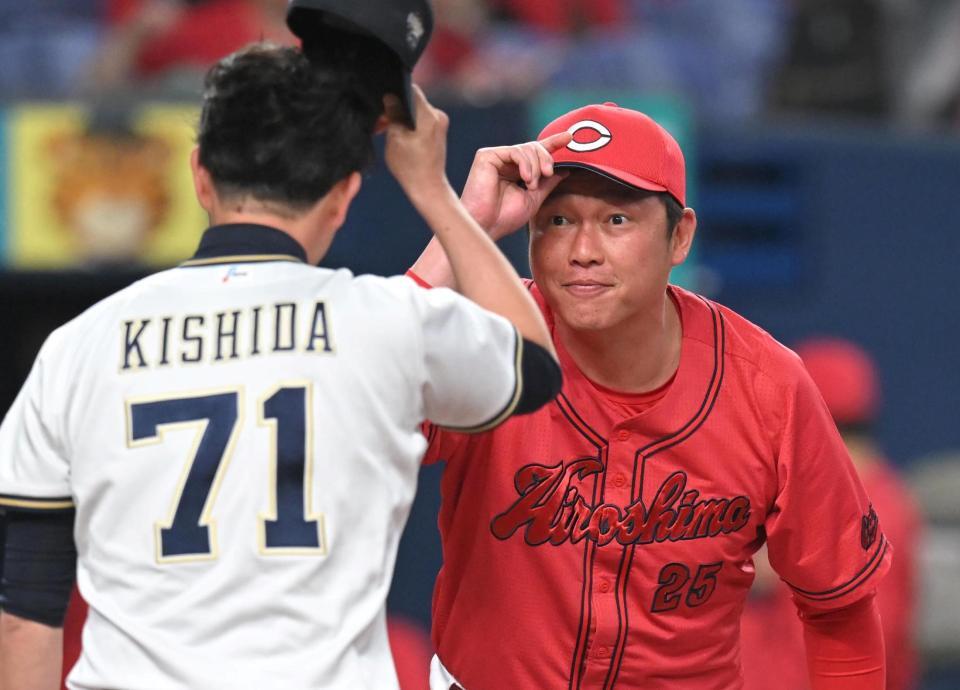 　岸田監督とあいさつを交わす新井監督（撮影・飯室逸平）