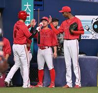 　４回、矢野の勝ち越し打で生還した秋山（左）を迎える上本とアドゥワ＝撮影・西田忠信