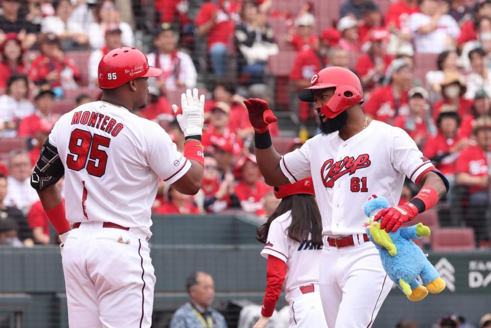 　１回、左越えソロを放ち、モンテロとタッチをするファビアン（撮影・市尻達拡）